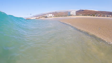 Nahaufnahme-Der-Ozeanwelle,-Die-Auf-Die-Sandküste-In-Fuerteventura,-Kanarische-Inseln,-Spanien,-Rollt-Und-Spritzt