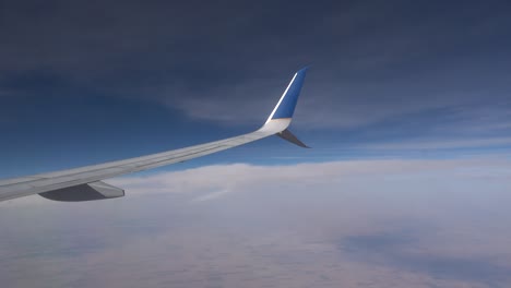 Blick-Auf-Den-Himmel-Und-Die-Tragfläche-Aus-Dem-Flugzeugfenster,-Nachmittagsflug