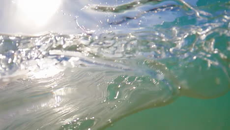 Blaues-Wasser-Von-Ozeanschwellen,-Das-Im-Sommer-Auf-Das-Kameraobjektiv-Spritzt