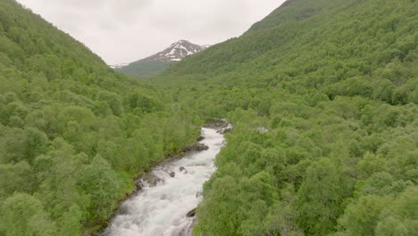 Fly-Over-Flowing-Mountain-Rocky-River-With-Dense-Trees-Near-Erdal-In-Vestland-County,-Norway