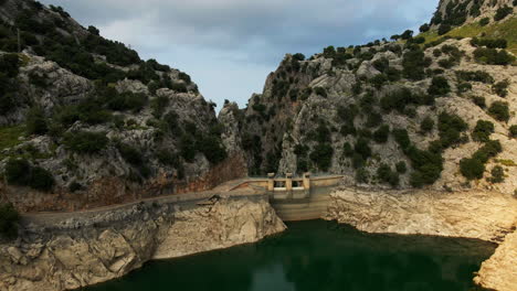 Aerial-slow-dramatic-zoom-into-dam-during-drought-with-low-water-level-reservoir-in-Spain