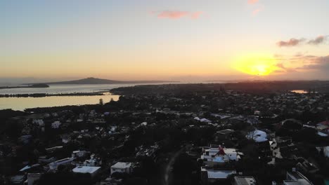Sunrise-over-coastal-Auckland-suburb-with-view-of-Rangitoto-island