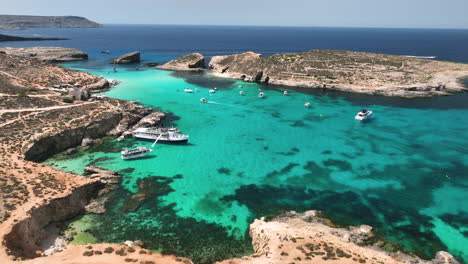 Drone-footage-flying-over-boats,-people,-and-jetskis-at-the-incredible-blue-lagoon-on-Comino-Island-in-Malta