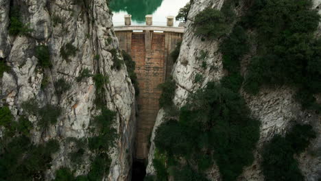 Aerial-tilt-up-dramatic-reveal-of-hydro-electric-dam-in-Spain-during-drought-with-overcast-sky-and-low-water-level