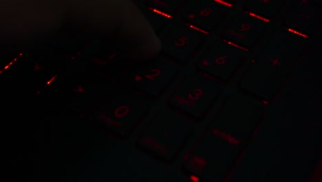 Nahaufnahme-Von-Fingern,-Die-Auf-Einer-Beleuchteten-Laptop-Tastatur-Nummer-Tippen