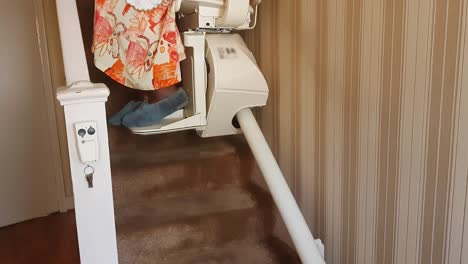 Elderly-woman,-of-African-ethnicity,-using-a-residential-stair-lift