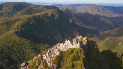 Flying-over-a-jagged-rocky-pinnacles-outcrop-on-a-sunny-day-reveals-a-moody-horizon