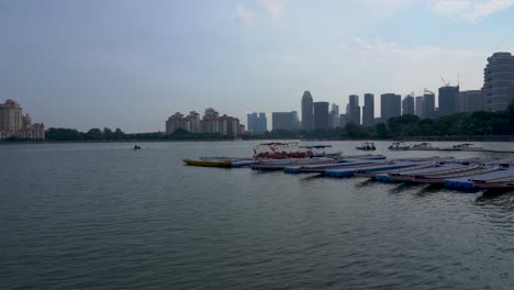 Scenic-view-of-Kallang-Basin,-dragon-boats-at-the-pier-against-Singapore-cityscape