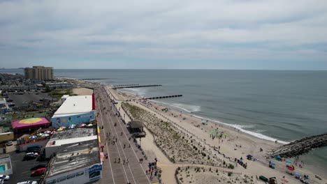 Aerial-shot-over-a-Jersey-Shore-boardwalk-with-waves-crashing-on-the-beach