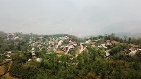 An-aerial-shot-of-a-country-town-on-top-of-a-foggy-valley-in-the-hills