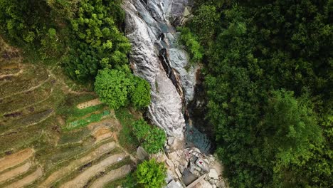 Absteigende-Luftaufnahme-Von-Menschen,-Die-In-Einer-Lagune-Am-Fuße-Eines-Wasserfalls-Baden