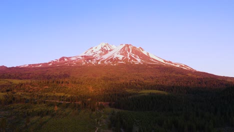 Mount-Shasta-is-bathed-in-red,-pink-and-yellow-light-at-sunset