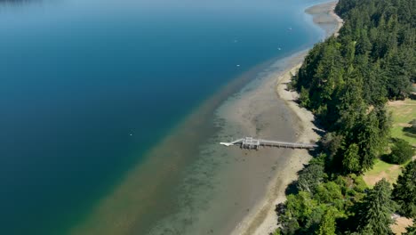 Aerial-view-of-a-private-dock-extending-from-Freeland,-Washington's-shore-out-into-the-Pacific-Ocean