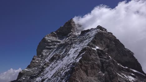 Vista-Aérea-Ascendente-Del-Pico-Irregular-Del-Matterhorn,-Una-Montaña-De-Los-Alpes,-Que-Se-Extiende-A-Ambos-Lados-De-La-Frontera-Entre-Suiza-E-Italia