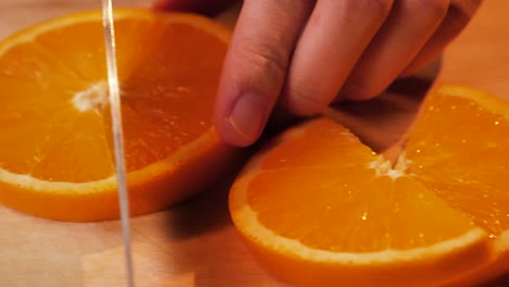 A-slice-of-orange-being-cut-in-slow-motion,-UHD-1