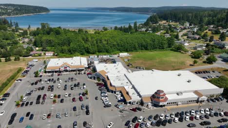 Aerial-of-a-shopping-outlet-in-Freeland,-Washington-with-the-Pacific-Ocean-off-in-the-distance