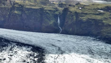 Waterfall-Flowing-Into-Sólheimajökull-Glacier-In-South-Iceland