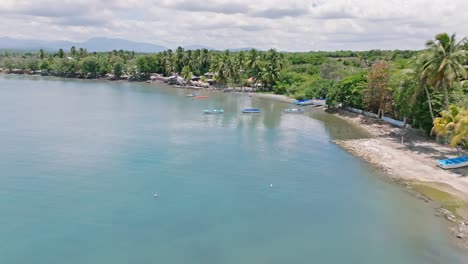 Fishing-Boats-On-The-Tranquil-Ocean-Of-Playa-Palenque-In-San-Cristobal,-Dominican-Republic---drone-shot