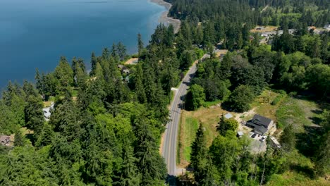 Drone-shot-of-a-road-running-parallel-to-the-Freeland,-Washington-shoreline