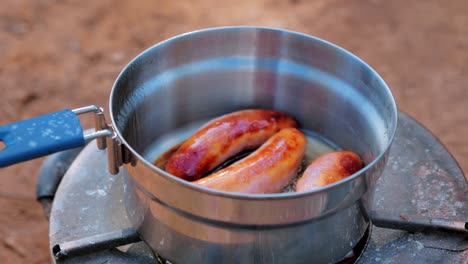 Kooking-Breakfast-Sausage-In-Pan-In-The-Forest