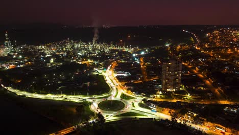 Aerial-hyperlapse-of-traffic-in-Concon-roundabout-illuminated-at-night-with-smoke-from-ENAP-Aconcagua-refinery,-Valparaiso,-Chile