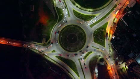 Aerial-top-down-of-cars-driving-in-busy-avenues-in-Concon-roundabout-illuminated-at-night,-Valparaiso,-Chile