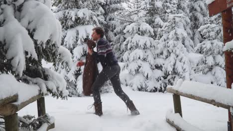 Caucasian-man-in-casual-winter-clothing-walking-in-winter-forest-and-grabbing-his-brown-Jacket-to-wear
