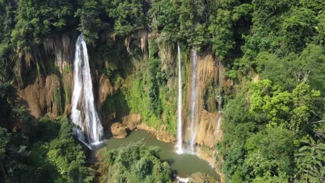 A-stunning-drone-shot,-flying-away-from-the-tropical-Thi-Lo-Su-Waterfall-located-off-the-beaten-track-in-backpackers-paradise-of-North-Thailand-in-the-area-of-Umphang-in-Southeast-Asia