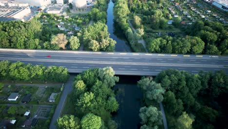 Passenger-cars-drive-over-a-bridge-over-the-river-Oker-from-the-German-highway-A392-in-and-out-of-the-city-of-Braunschweig-between-the-green-nature-of-the-city