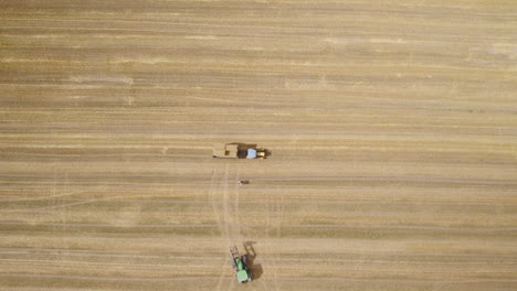 Aerial-view-of-hay-bale-load-on-tractor-trailer,-farming-season-in-Europe