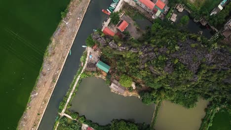 Aerial-shot-of-houses-or-businesses-along-a-canal-with-a-reveal-of-small-boats