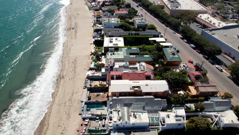 Aerial-view-looking-down-at-wealthy-seafront-homes-on-Malibu-beach-In-California