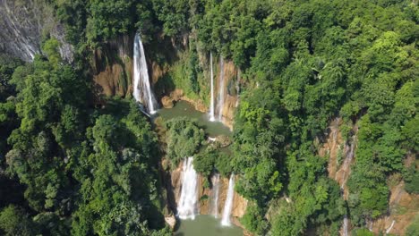 Drone-shot-flying-away-from-Thi-Lo-Su-Waterfall-and-seen-from-above,-located-deep-in-the-jungle,-off-the-beaten-track-of-North-Thailand-in-the-area-of-Umphang-in-Southeast-Asia