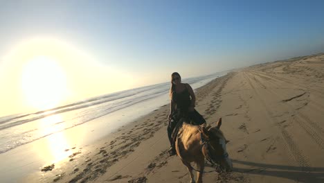 Beautiful-woman-horseback-riding-on-the-beach-during-sunset