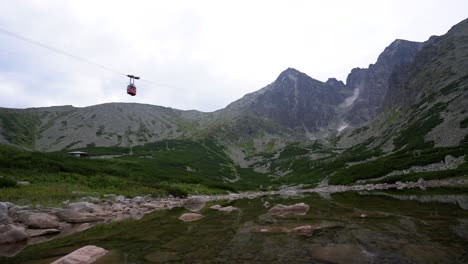 Cable-car-traveling-up-to-Lomnica-peak,-view-over-Skalnate-Pleso