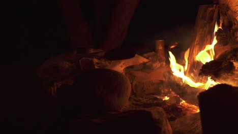 Camp-fire-burning-in-eerie-dark-night-with-animal-skull-in-the-background