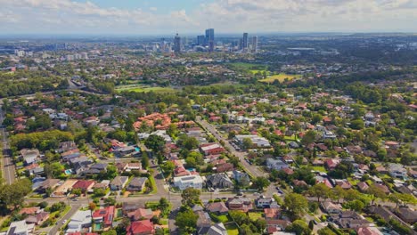 Drone-of-houses-and-horizon-view-of-the-city-in-the-distance-Sydney,-Australia