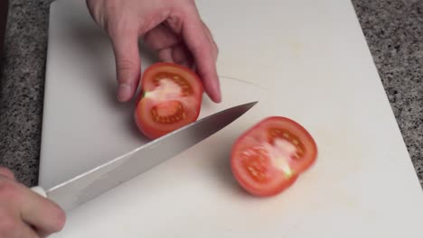 Fresh-And-Ripe-Tomato-Being-Sliced-Evenly-In-The-Cutting-Board-By-A-Cook