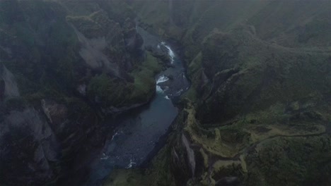 Drone-shot-flying-over-cloudy-Fjaðrárgljúfur-canyon-with-the-camera-tilted-down-in-Iceland-4k