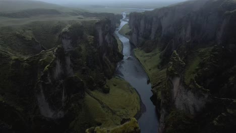 Flight-over-and-through-cloudy-Fjaðrárgljúfur-canyon-in-Iceland-4k