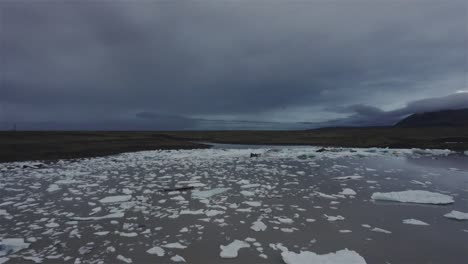 Drone-Volando-En-Círculo-Sobre-Un-Lago-Con-Trozos-De-Hielo-Hacia-Un-Gran-Glaciar-En-Islandia-4k