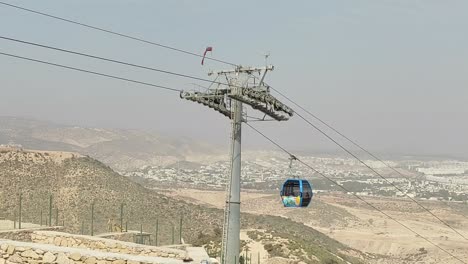 Cable-car-of-the-aerial-tramway-connecting-Oufella-peak-and-Agadir-city-in-Morocco,-overlooking-a-panoramic-view-of-the-beach-7
