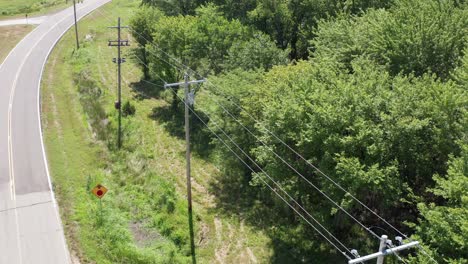 Close-up-aerial-shot-flying-over-a-rural-utility-pole-and-powerline-inspection