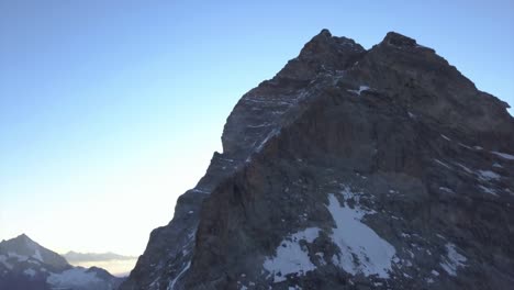 Vista-Aérea-Del-Matterhorn-Desde-Un-Dron-Que-Desciende-Con-Un-Paisaje-Accidentado,-Acantilados-Escarpados,-Nieve-Y-Hielo-En-La-Montaña