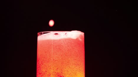 Ice-cubes-falling-in-a-red-light-juice