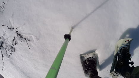 Eine-Action-kameraaufnahme-Eines-Winterwanderers-Mit-Schneeschuhen,-Der-Mit-Einem-Trekkingstock-Auf-Kodiak-Island,-Alaska,-Einen-Berg-Hinaufgeht