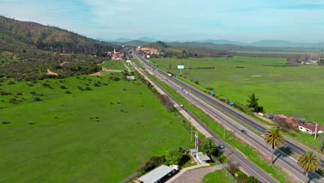 Aerial-view-dolly-in-route-68-Chile-Santiago-Valparaiso-green-fields-cars-day
