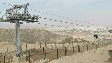 Cable-car-of-the-aerial-tramway-connecting-Oufella-peak-and-Agadir-city-in-Morocco,-overlooking-a-panoramic-view-of-the-beach-18