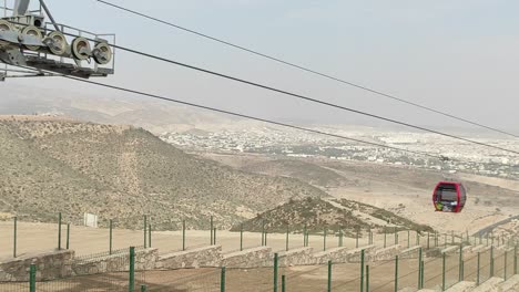 Cable-car-of-the-aerial-tramway-connecting-Oufella-peak-and-Agadir-city-in-Morocco,-overlooking-a-panoramic-view-of-the-beach-17