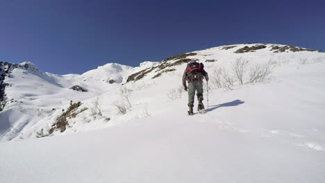Un-Excursionista-De-Invierno-Sube-Con-Raquetas-De-Nieve-A-Las-Montañas-Cubiertas-De-Nieve-De-La-Isla-De-Kodiak,-Alaska